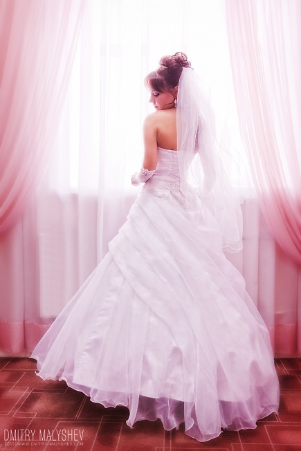 Невеста в пышном платье у окна
