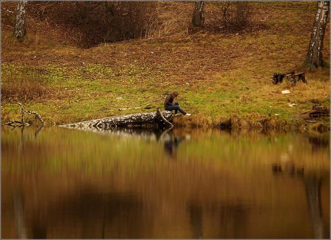 Грустная девушка смотрит на свое отражение в водах Скитского пруда поздней осенью...